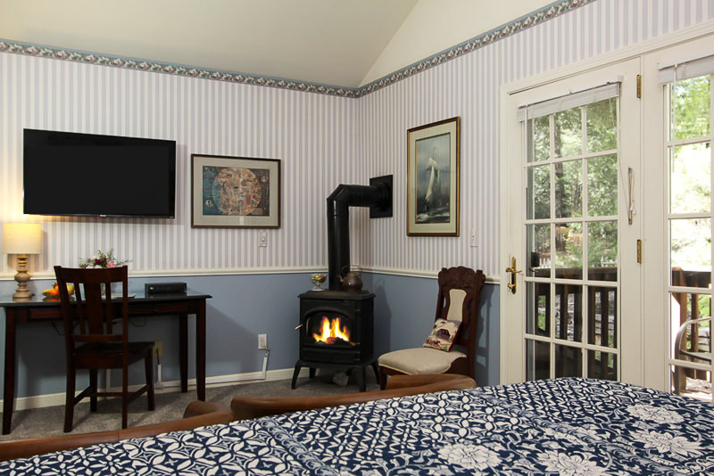 wedgwood room with bed, chairs, firestove